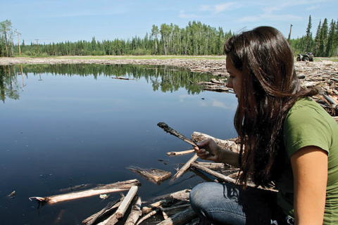 July 2011- Little Buffalo band member Melia Laboucan-Massimo scoops by oil from near the site of a Plains Midstream spill. 