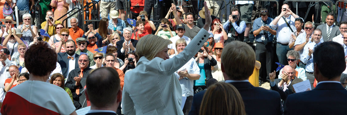 Rachel Notley waving to a crowd of people