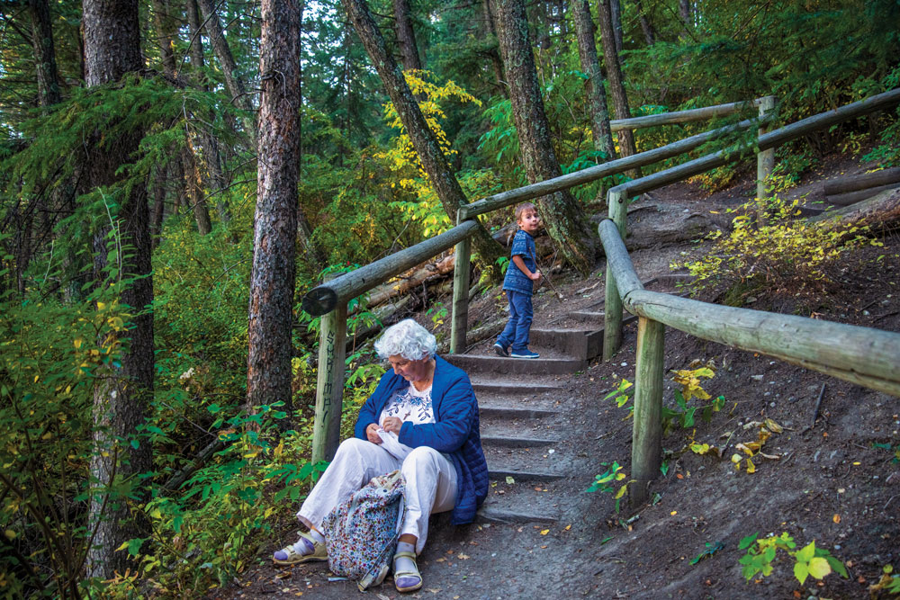 A child and a Grandparent sitting on a hiking trail