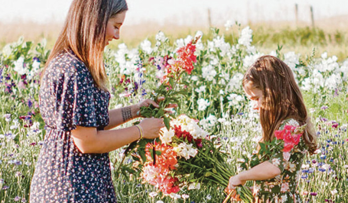 A mother and daughter harvesting flowers