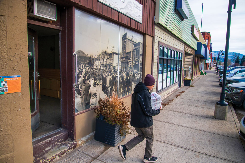 A stack of newspapers carried by a young person (Photography by Guillaume Nolet)