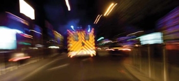 An ambulance is rushing down a street, lights blurring past. will the paramedic arrive too late